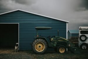 Green tractor in front of shed